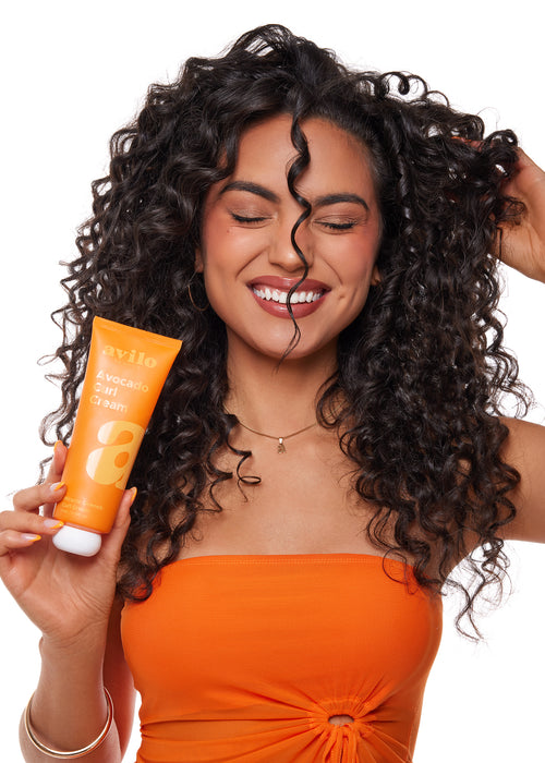Woman holding an Aviva product with a split effect showing hair care benefits.