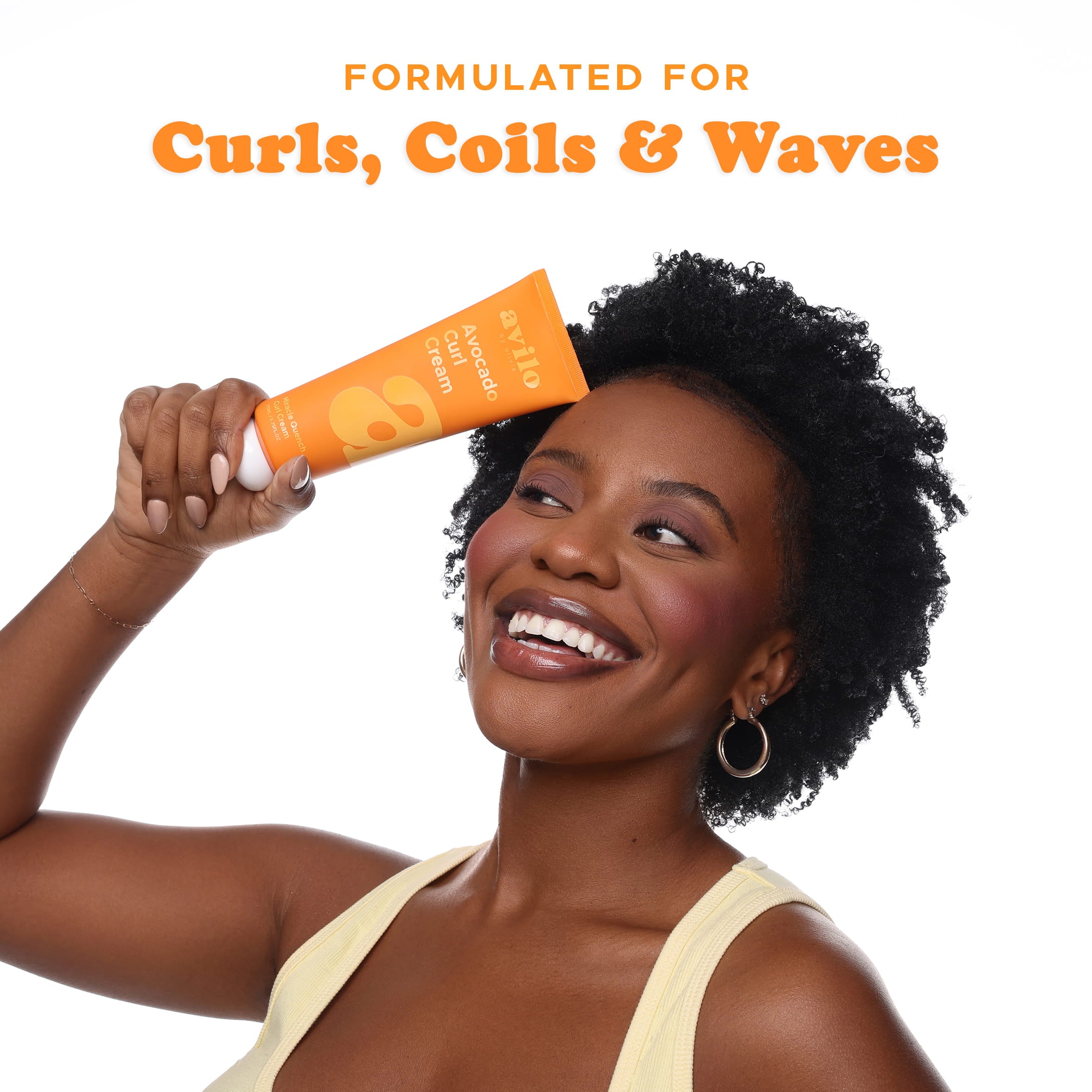 Woman holding an orange tube of hair care product with text 'Formulated for Curls, Coils & Waves' on a white background