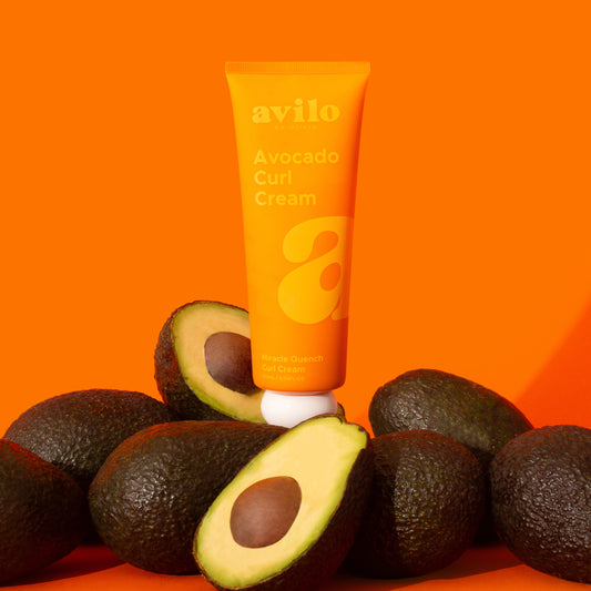 Avocado Curl Cream tube with avocados on an orange background