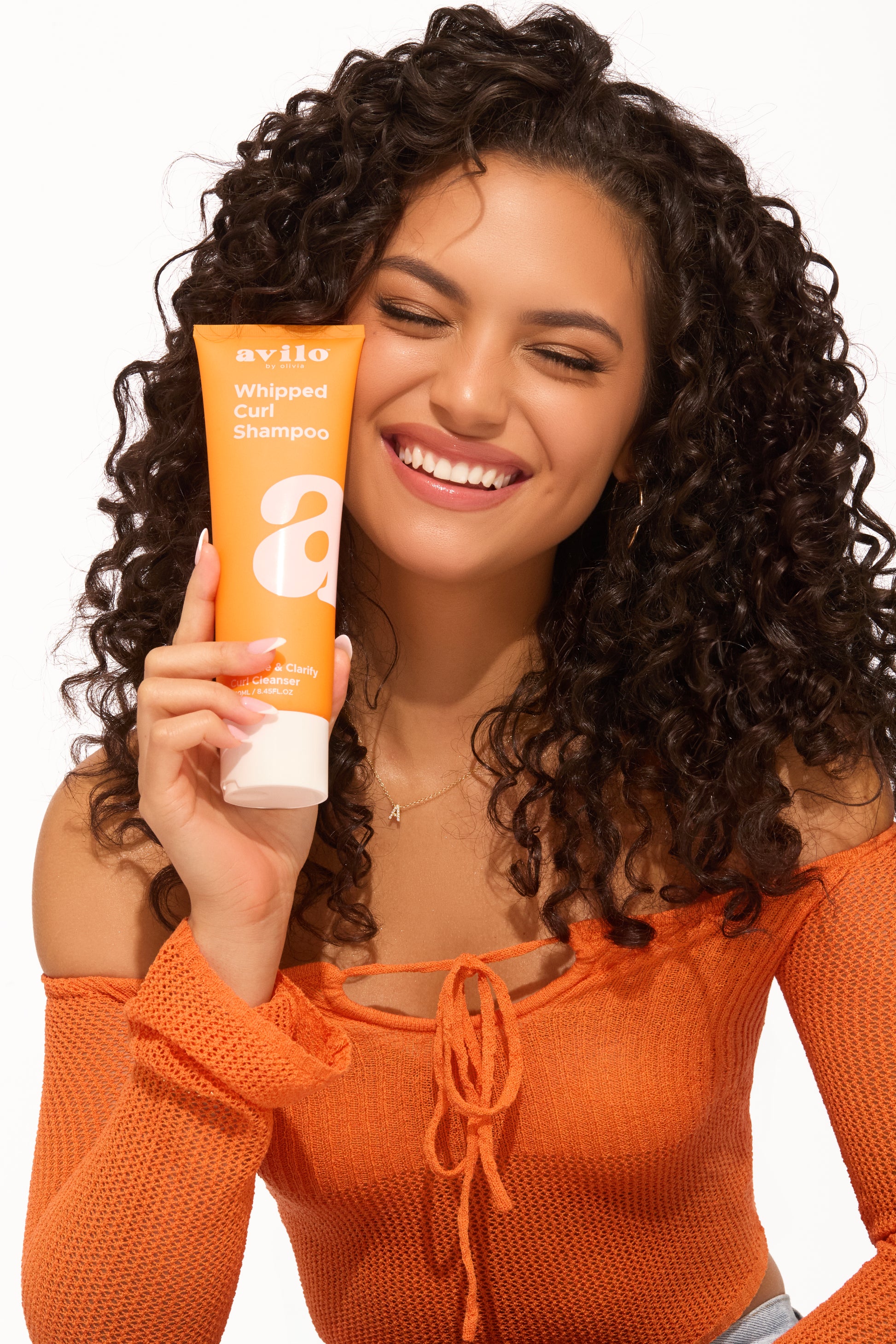 curly hair girl showing avilo shampoo