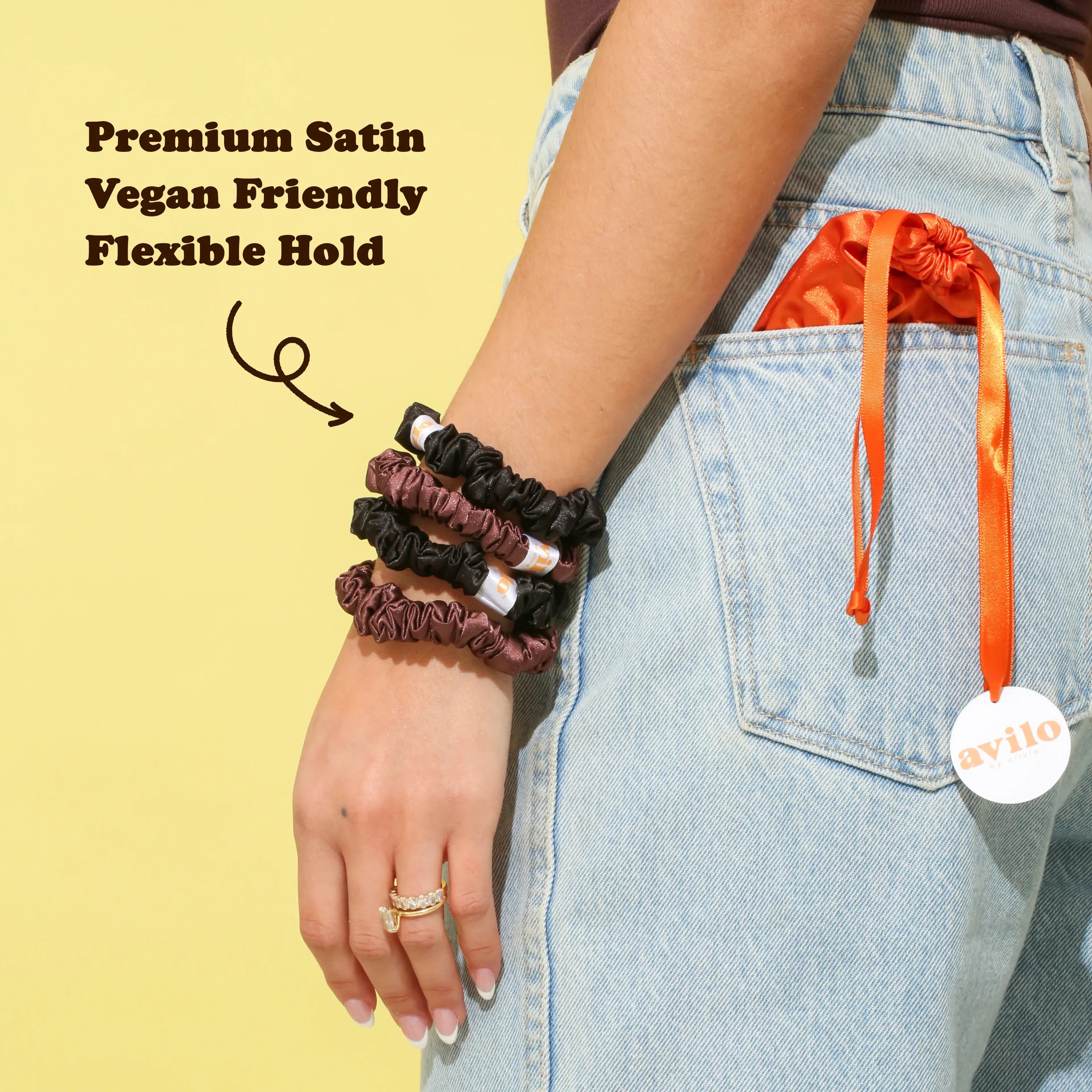 Person wearing multiple hair ties with an orange drawstring bag on a yellow background