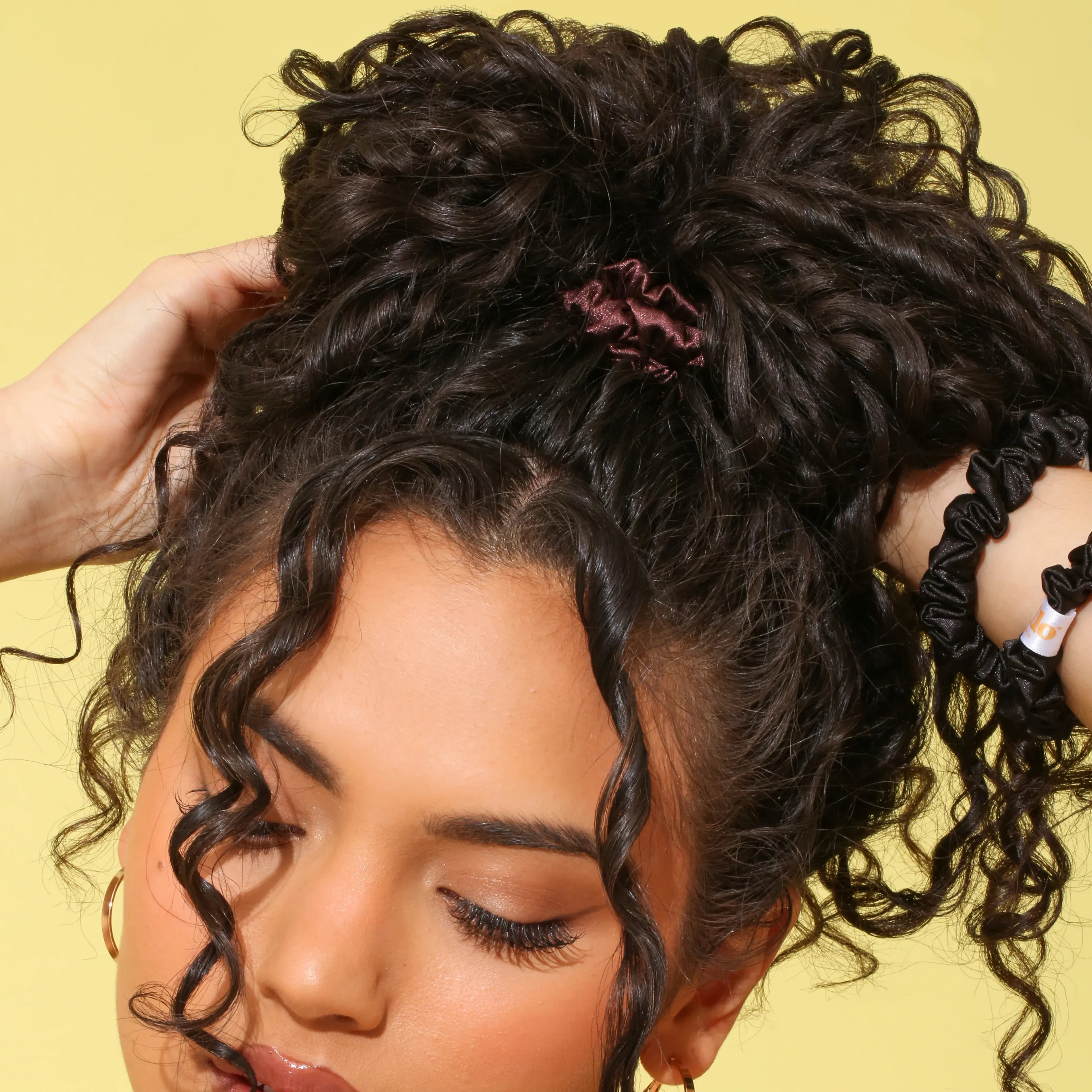 Close-up of a person with styled hair against a yellow background