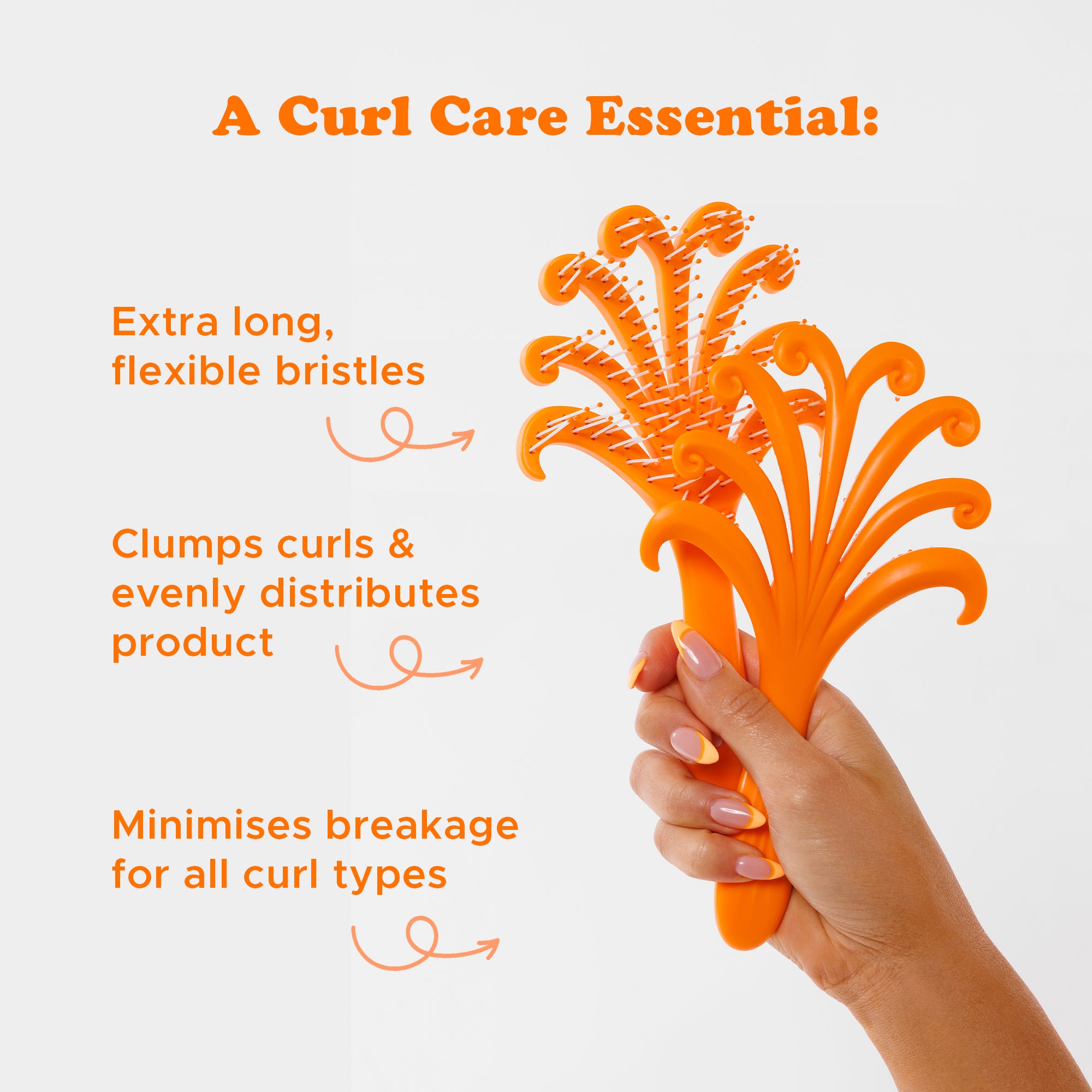 Orange hairbrush held by a hand with text highlighting its features on a white background