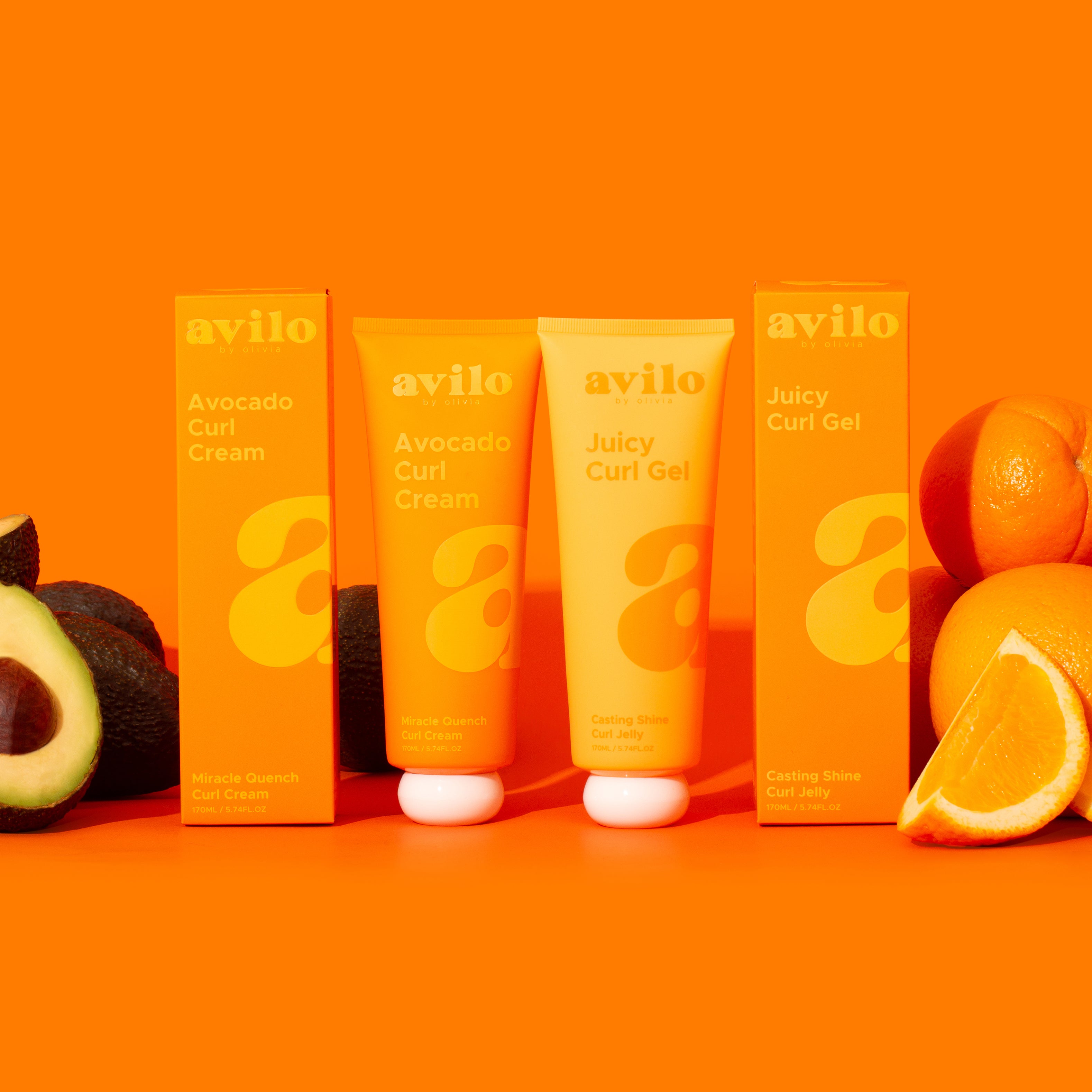 Avilo hair care products with avocado and orange on an orange background
