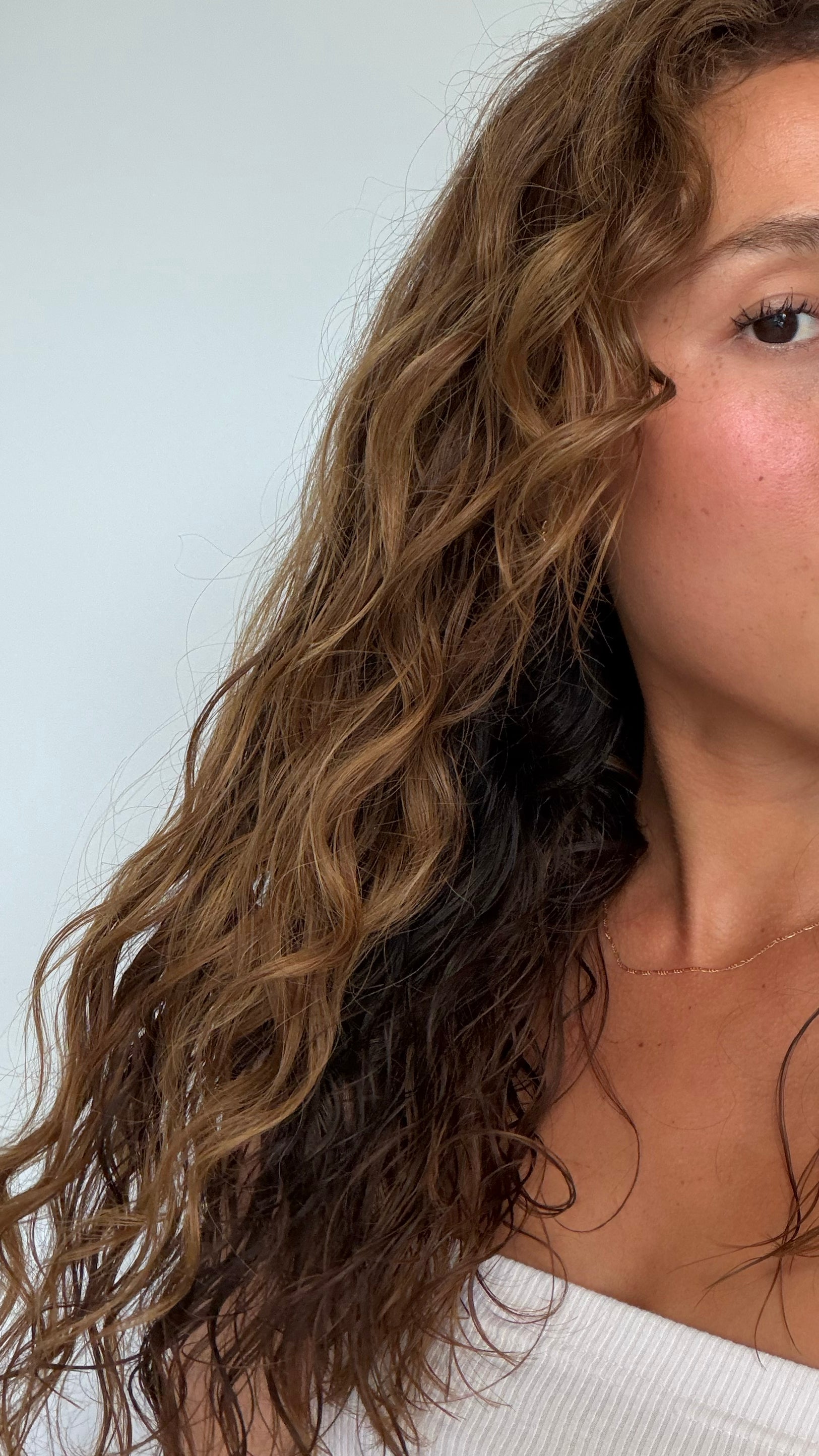 Close-up of a person with wavy hair against a white background
