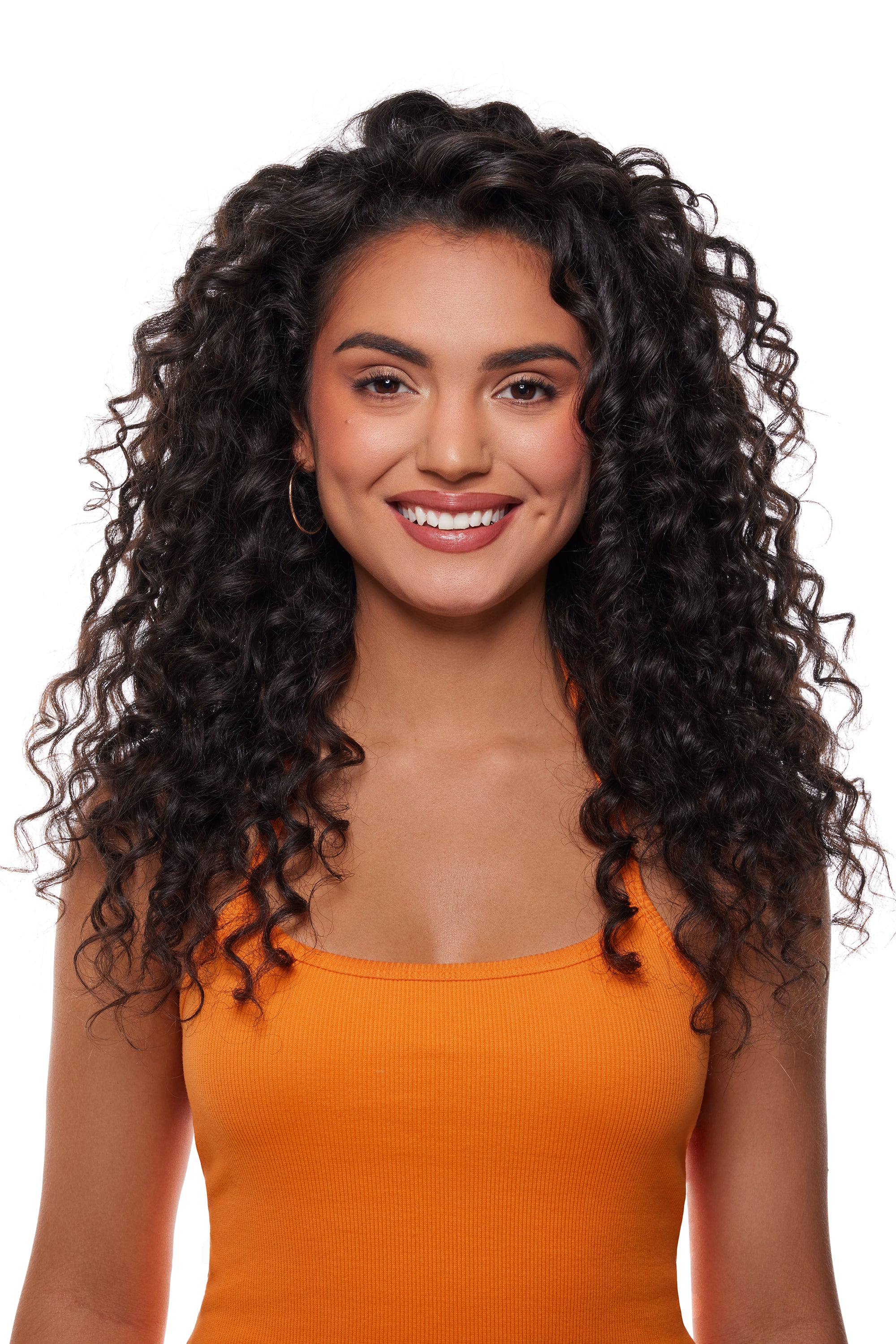 Woman with long, curly hair wearing an orange top on a white background

