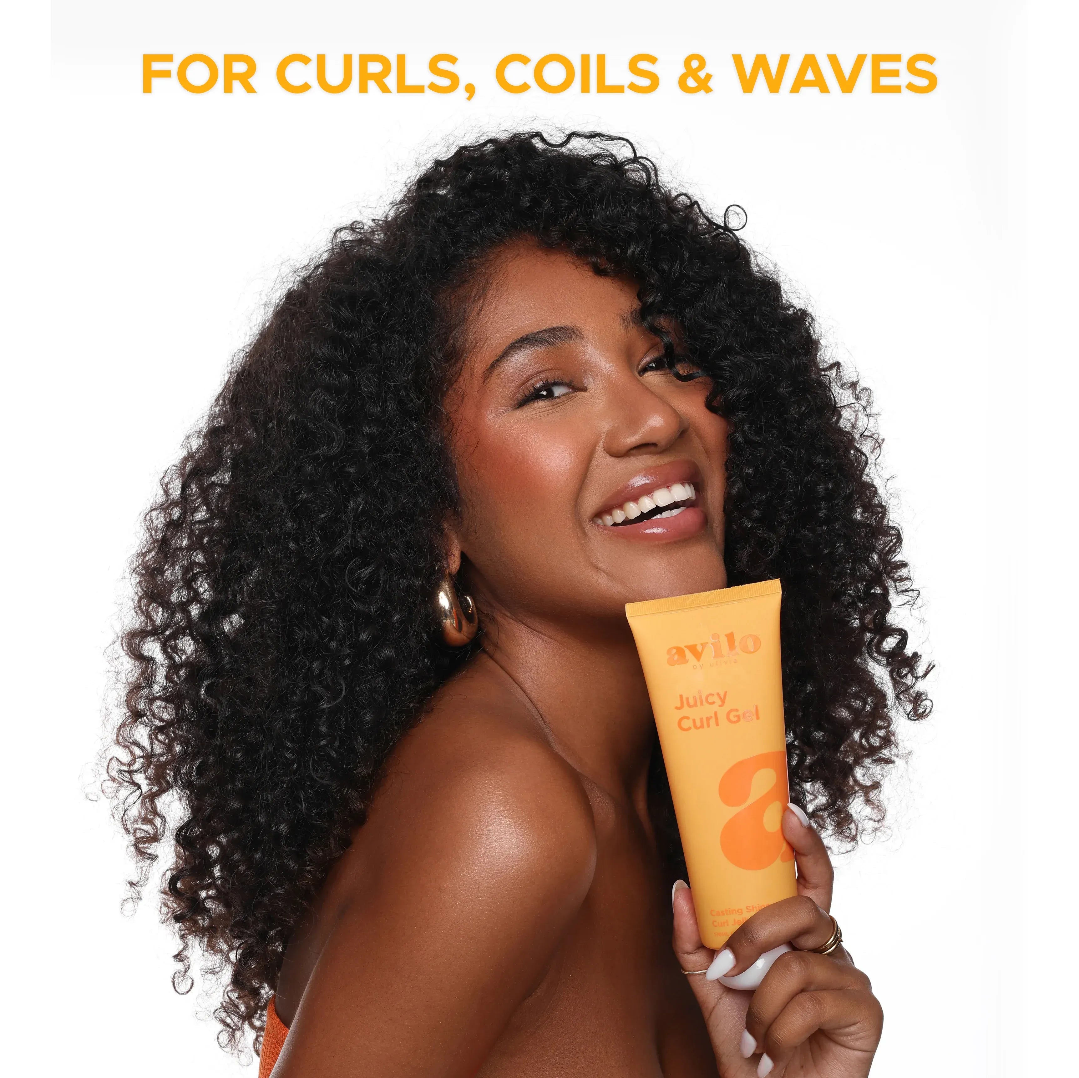 Woman with curly hair holding a bottle of Juicy Curlz product with text 'For Curls, Coils & Waves' above.